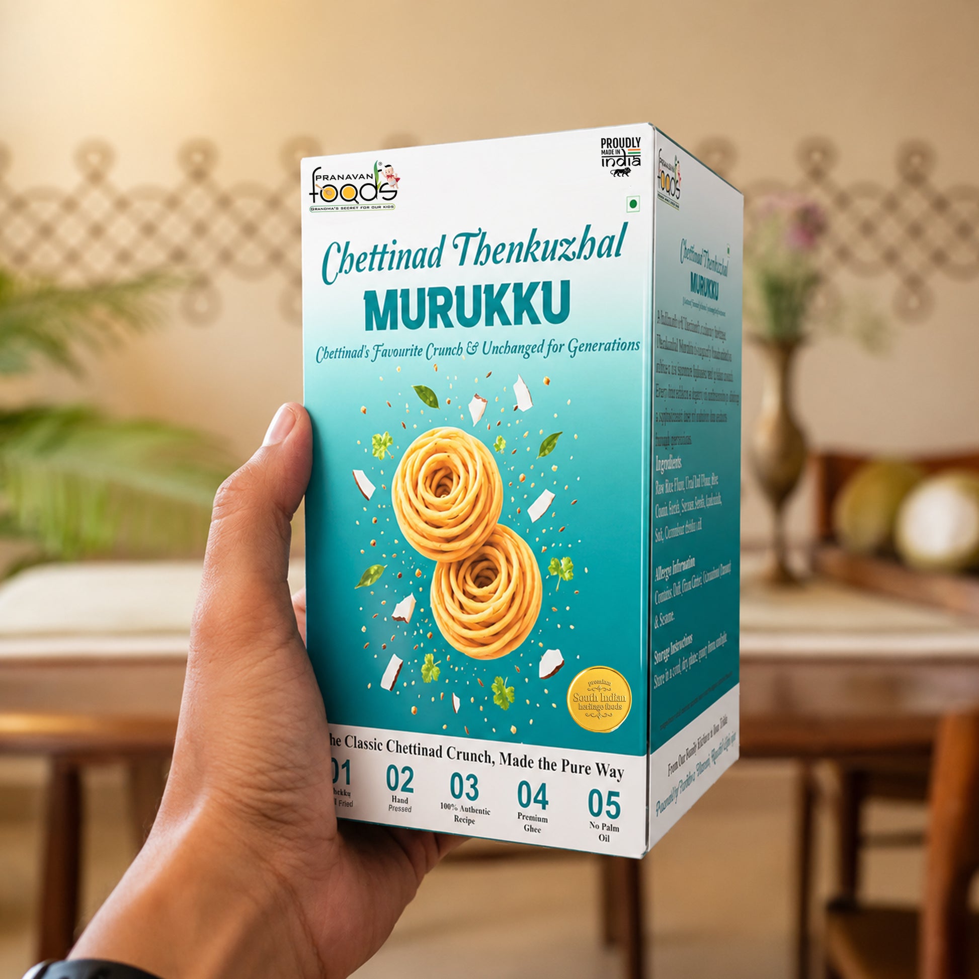 A hand holding a box of Chettinad Thenkuzhal Murukku, a traditional Indian chettinad snack, against a blurred indoor background.
