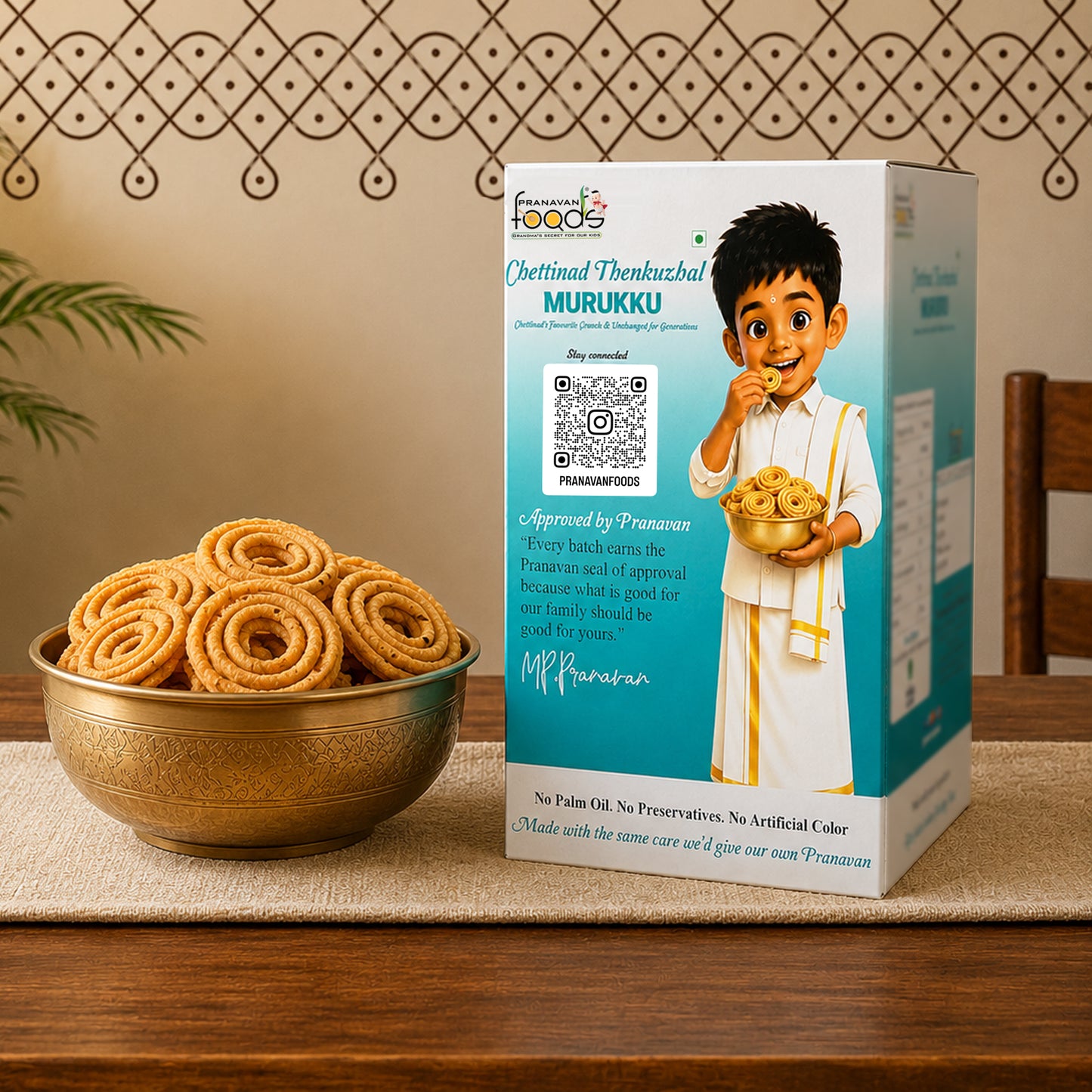 A box of Chettinadi Thankuzhal Murrukku alongside a brass bowl filled with golden-brown fried sweet rolls, set on a wooden table with a patterned wall in the background.